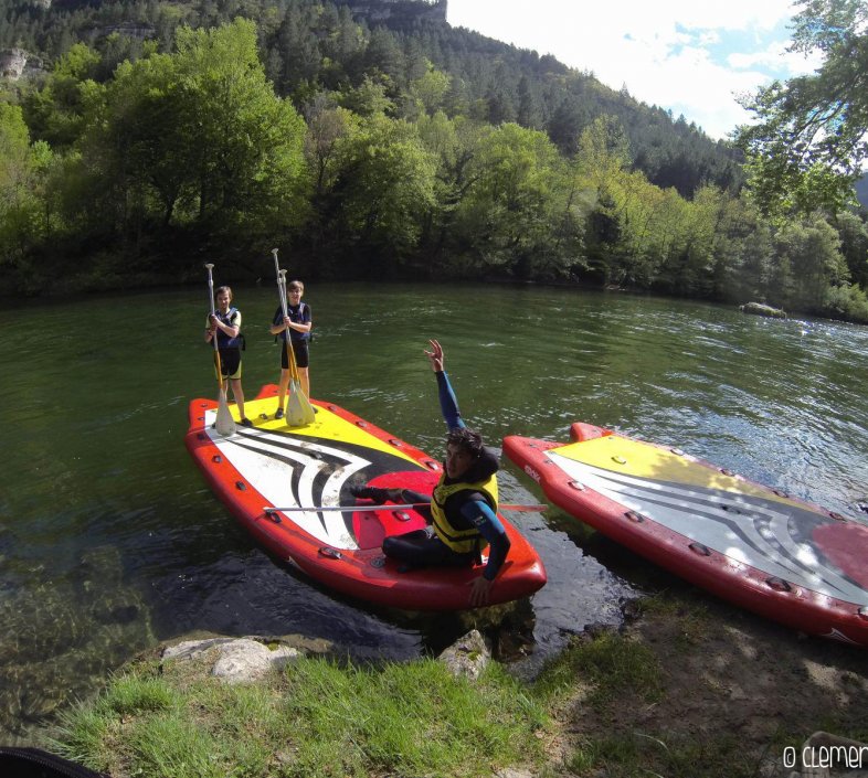 Trois personnes font du paddle en groupe dans les Gorges du Tarn avec Canoe Mejean