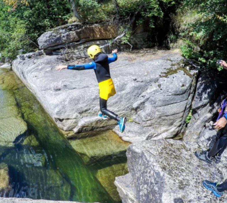 Une personne saute dans l'eau durant une session de canyoning dans les Gorges du Tarn avec Canoe Mejean